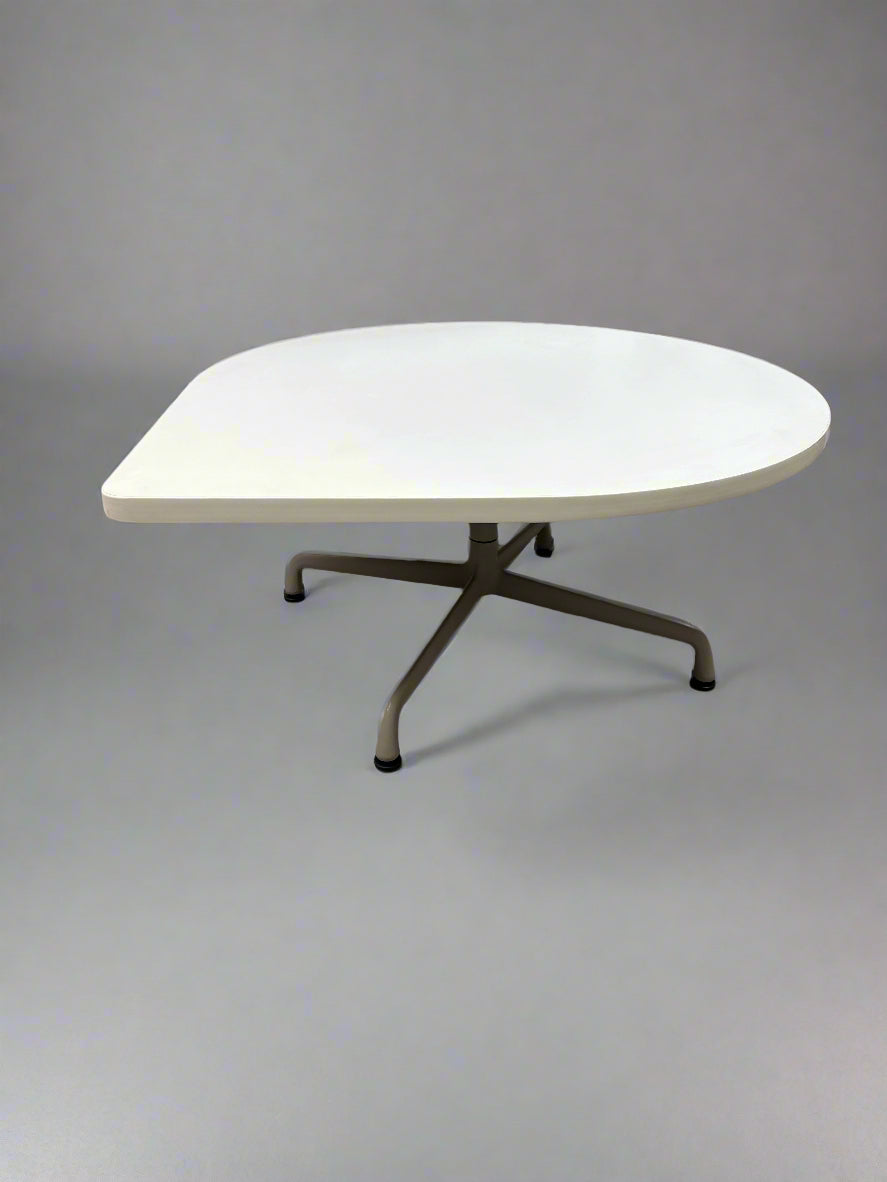 White round table on a tiled floor with a chair partially visible.