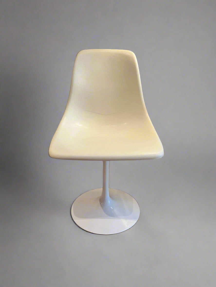 White swivel chair on a wooden floor with a small table in the background.