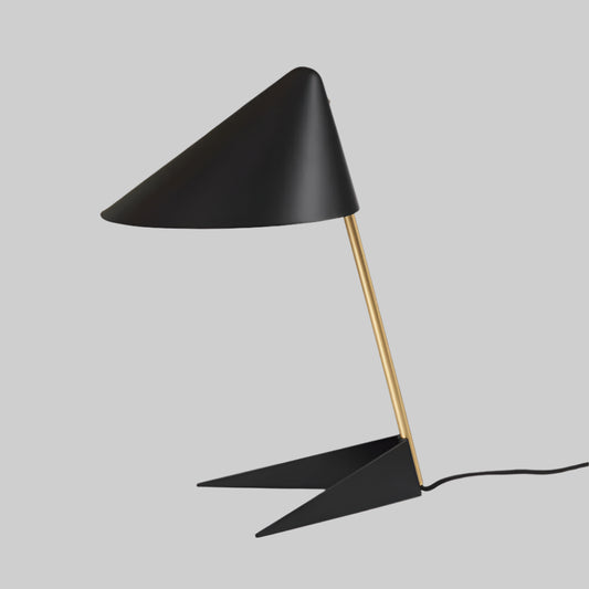 Modern black table lamp with gold stem on a white background