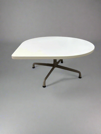 White round table on a tiled floor with a chair partially visible.
