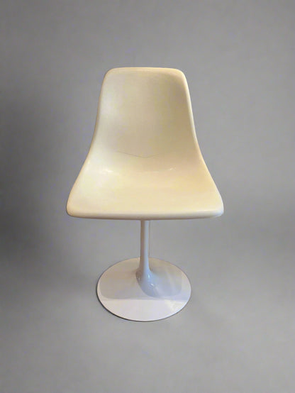 White swivel chair on a wooden floor with a small table in the background.